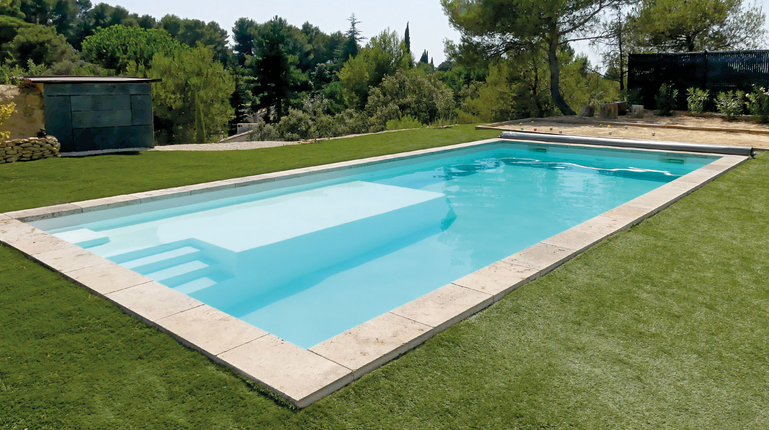Piscine coque polyester modèle Carry installée dans un jardin.