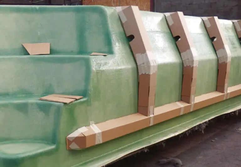 Pose de renforts structurels sur les parois d'une piscine coque en cours de fabrication.