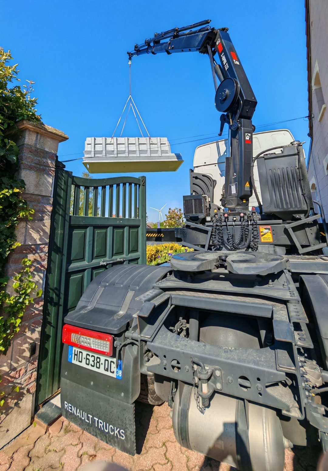 Camion Renault Trucks de CALABRO Logistics avec le bassin de piscine Mini Couloir suspendu au-dessus du portail d'une maison près de Caudry